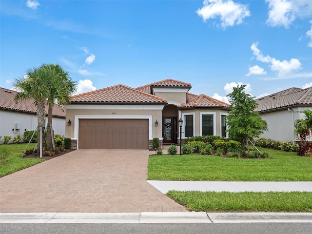 mediterranean / spanish house featuring decorative driveway, a tile roof, stucco siding, a front yard, and a garage