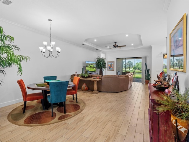 dining area with a tray ceiling, crown molding, recessed lighting, visible vents, and light wood-style floors