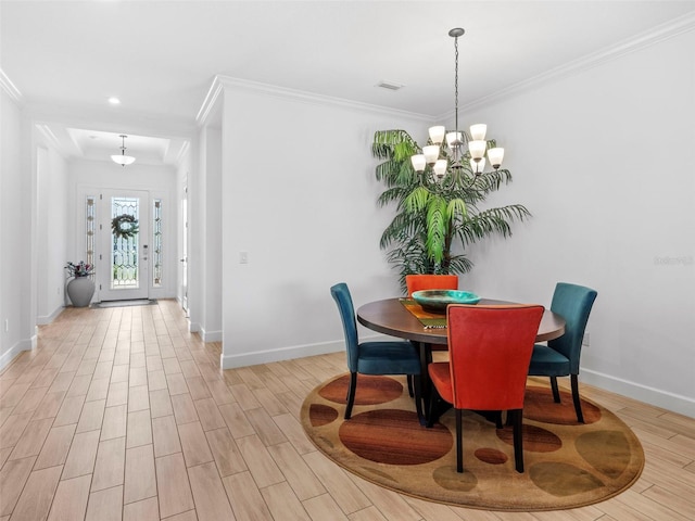 dining area featuring crown molding, light wood-type flooring, a notable chandelier, and baseboards