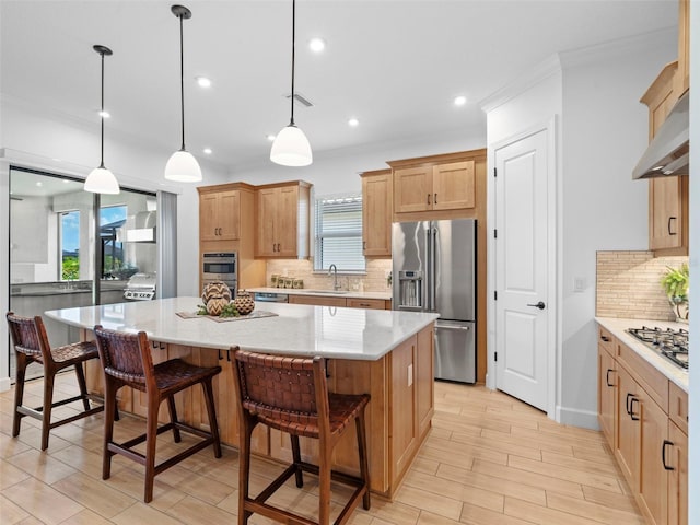 kitchen with appliances with stainless steel finishes, decorative light fixtures, and a spacious island