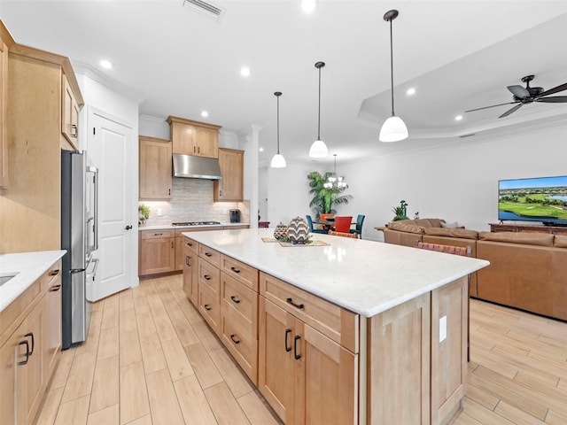 kitchen featuring open floor plan, decorative light fixtures, a center island, stainless steel appliances, and under cabinet range hood