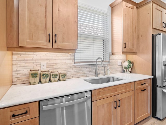 kitchen with light countertops, appliances with stainless steel finishes, backsplash, and a sink