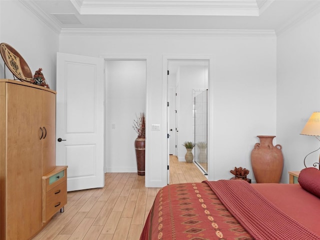 bedroom with ornamental molding, a raised ceiling, and light wood-style flooring