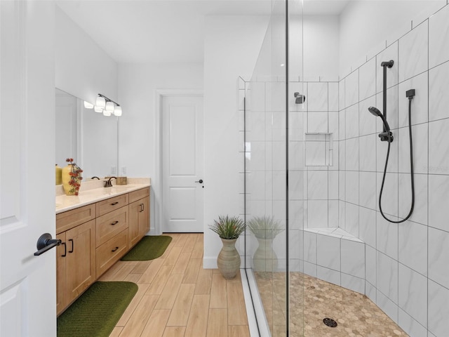 full bathroom featuring a walk in shower, wood finished floors, and vanity