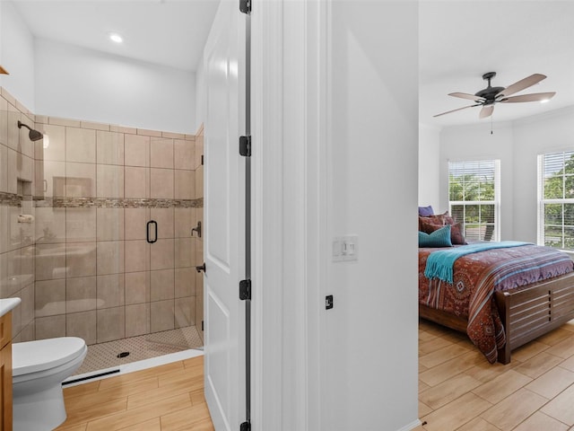 ensuite bathroom with a ceiling fan, connected bathroom, toilet, wood finish floors, and a shower stall