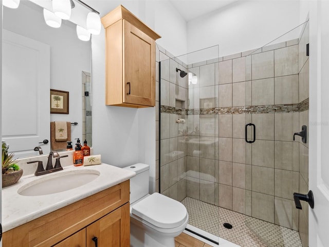 full bath featuring toilet, a stall shower, and vanity