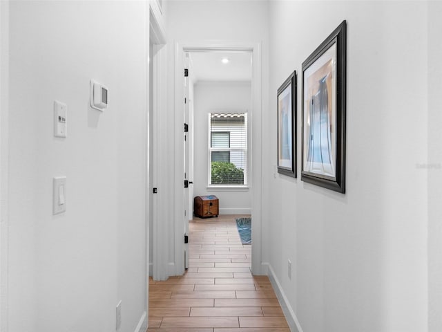 hallway with wood tiled floor and baseboards