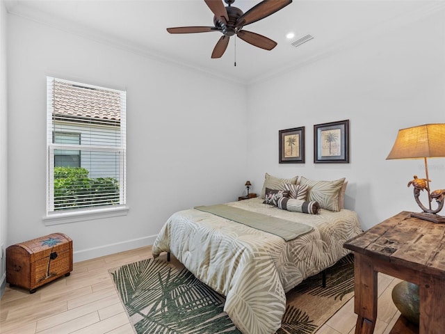 bedroom with ceiling fan, visible vents, baseboards, ornamental molding, and light wood finished floors