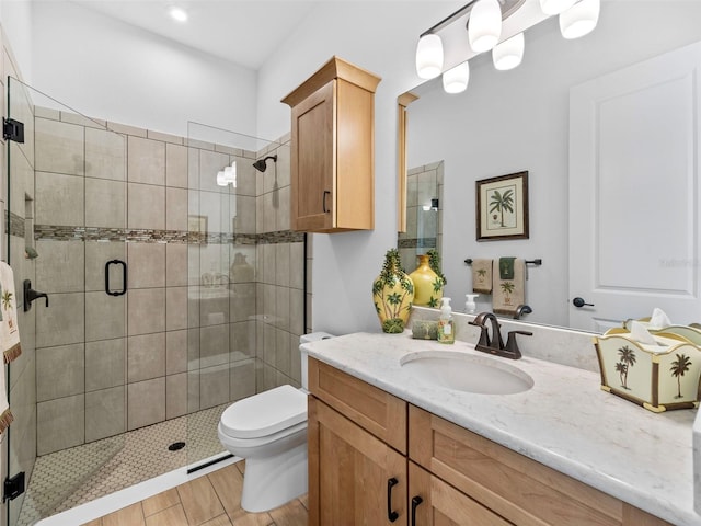 bathroom with a stall shower, vanity, and toilet