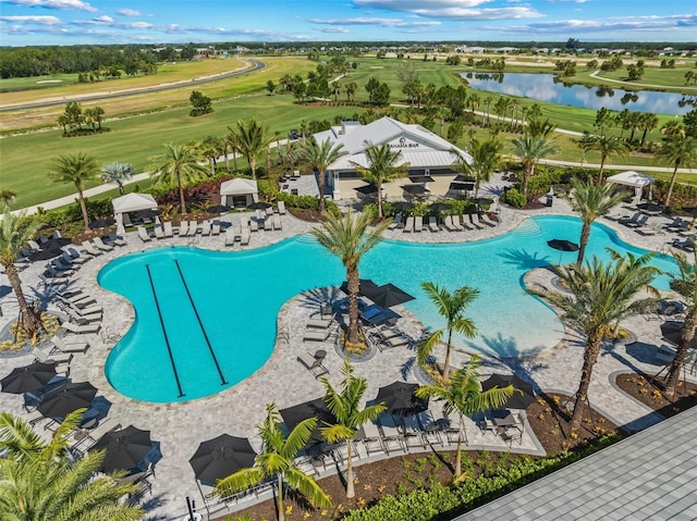 pool with a patio area and a water view