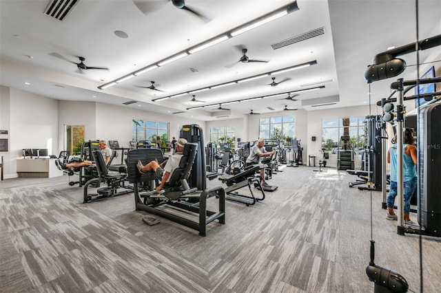 workout area with light carpet, visible vents, and a ceiling fan