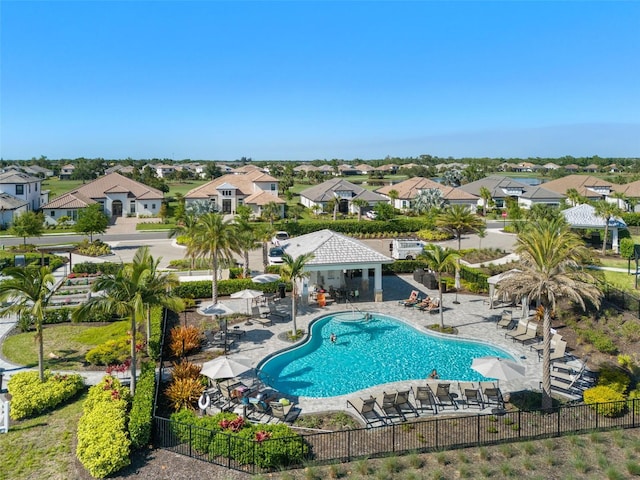 community pool with a patio area, a residential view, and fence