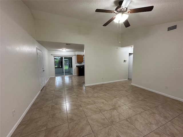 tiled empty room featuring a textured ceiling and ceiling fan