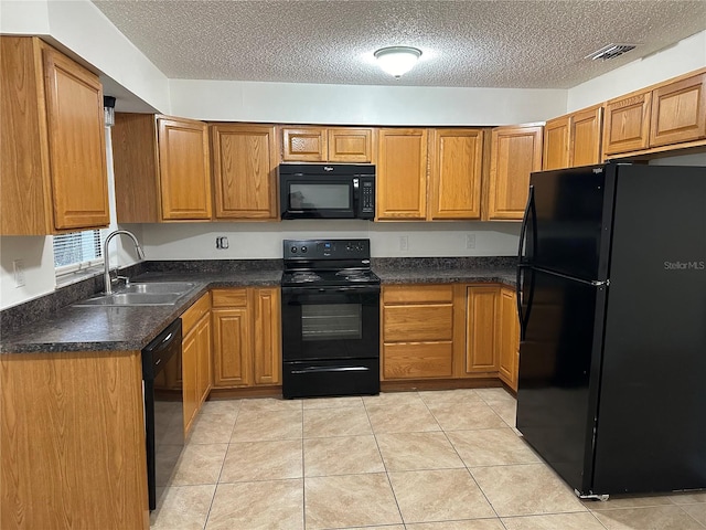 kitchen featuring black appliances, light tile patterned floors, sink, and a textured ceiling