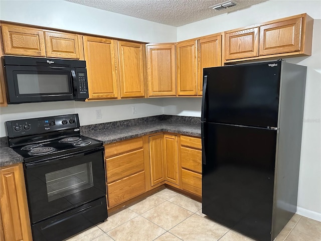 kitchen with a textured ceiling, light tile patterned floors, and black appliances