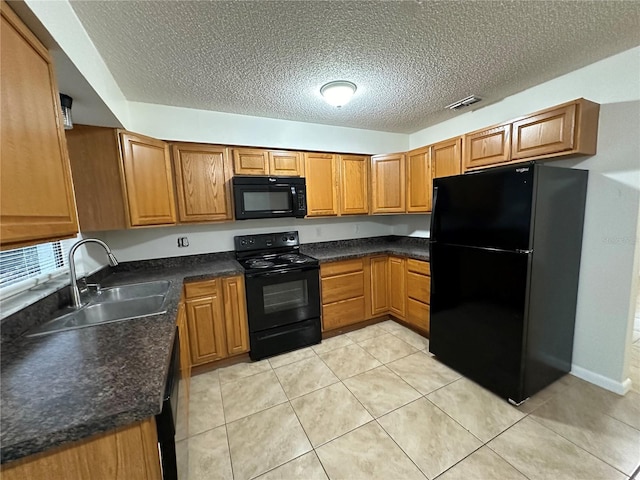 kitchen with sink, a textured ceiling, light tile patterned floors, and black appliances