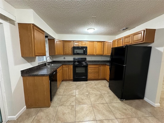 kitchen featuring a textured ceiling, light tile patterned floors, sink, and black appliances