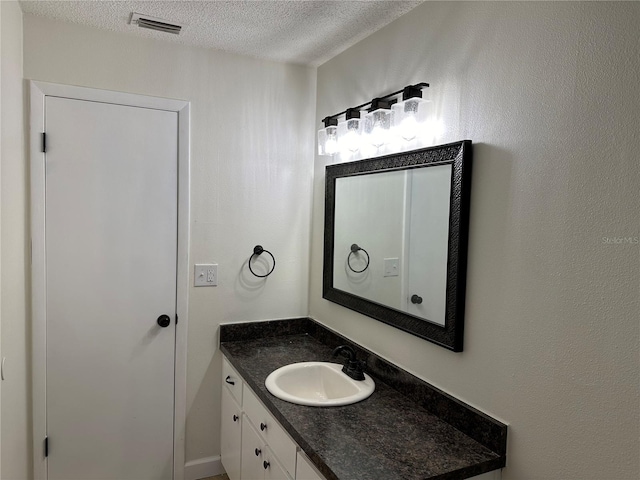 bathroom with a textured ceiling and vanity