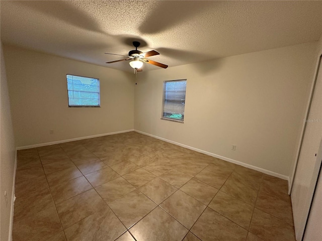 unfurnished room with ceiling fan, a textured ceiling, and light tile patterned floors