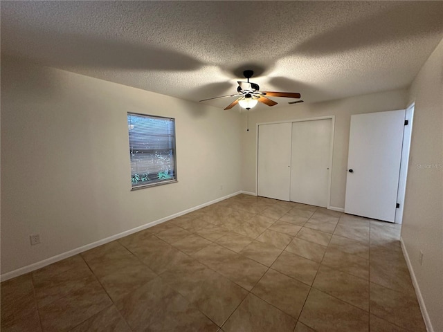 unfurnished bedroom featuring ceiling fan, a textured ceiling, and a closet