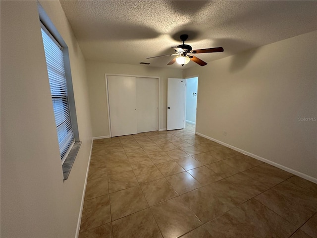 tiled spare room featuring ceiling fan and a textured ceiling