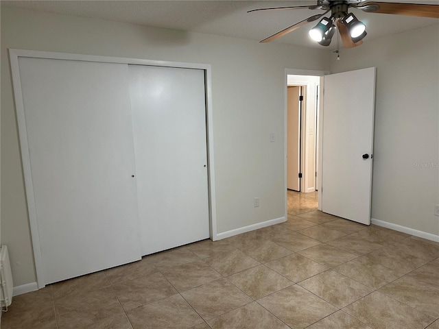 unfurnished bedroom featuring ceiling fan, light tile patterned floors, and a closet