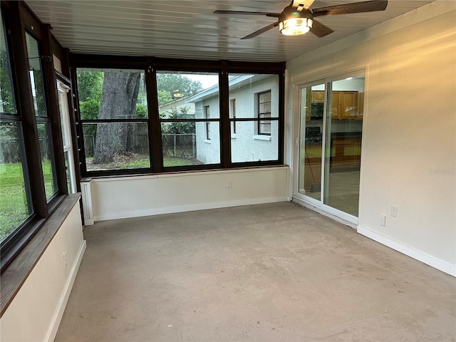 unfurnished sunroom with ceiling fan and plenty of natural light