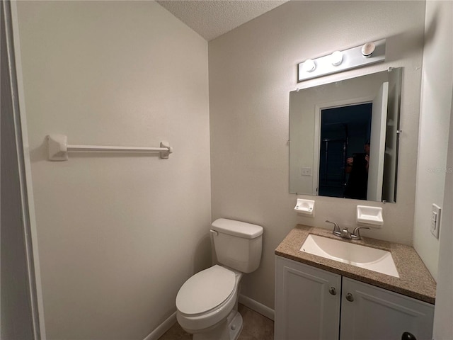 bathroom featuring toilet, vanity, tile patterned floors, and a textured ceiling