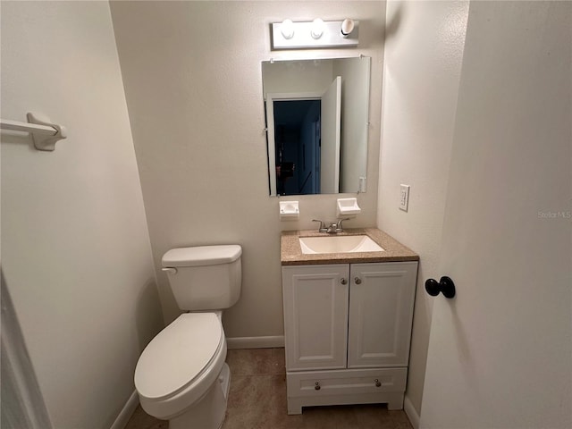 bathroom with toilet, tile patterned flooring, and vanity