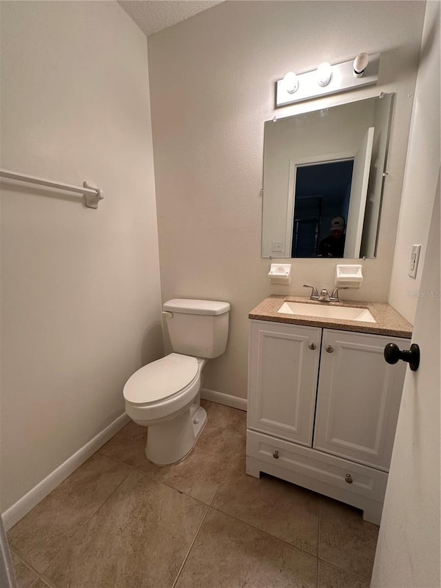 bathroom with toilet, tile patterned flooring, a textured ceiling, and vanity