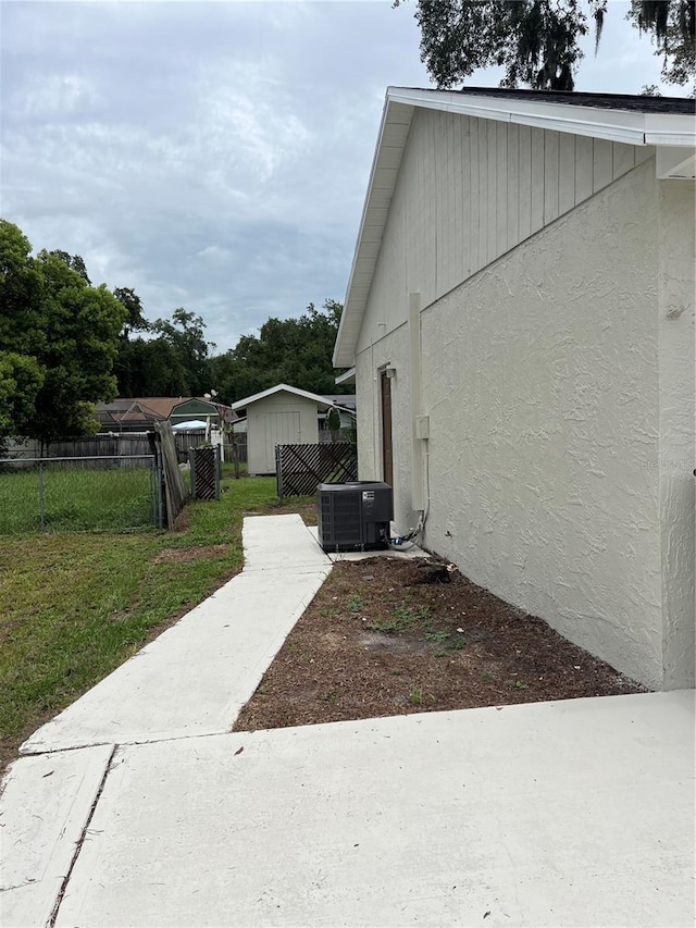 view of property exterior with a lawn and central AC