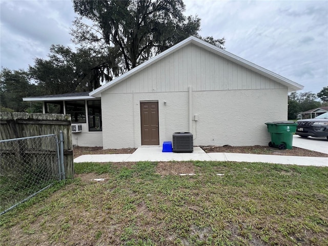 rear view of house featuring central AC and a yard