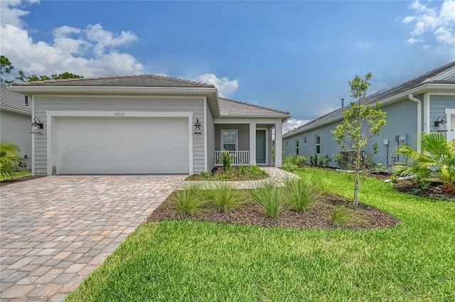 single story home with a porch, a garage, and a front lawn