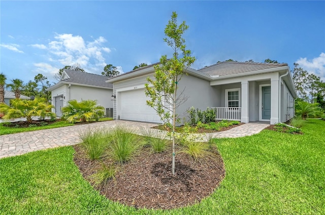 single story home featuring a porch, a garage, and a front lawn