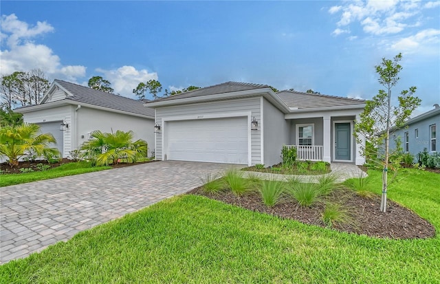 ranch-style home with a front yard, a porch, and a garage