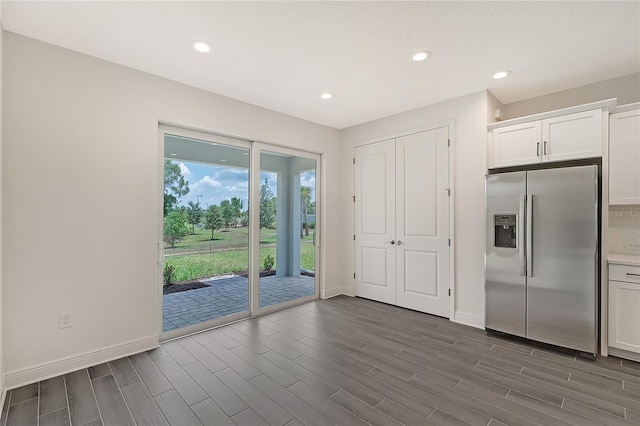 kitchen featuring backsplash, white cabinets, and stainless steel refrigerator with ice dispenser