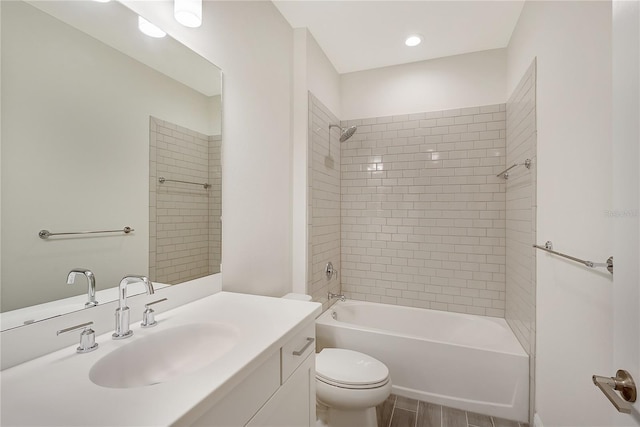 full bathroom with vanity, tiled shower / bath combo, and toilet