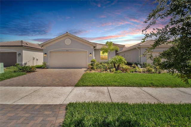 single story home featuring a lawn and a garage