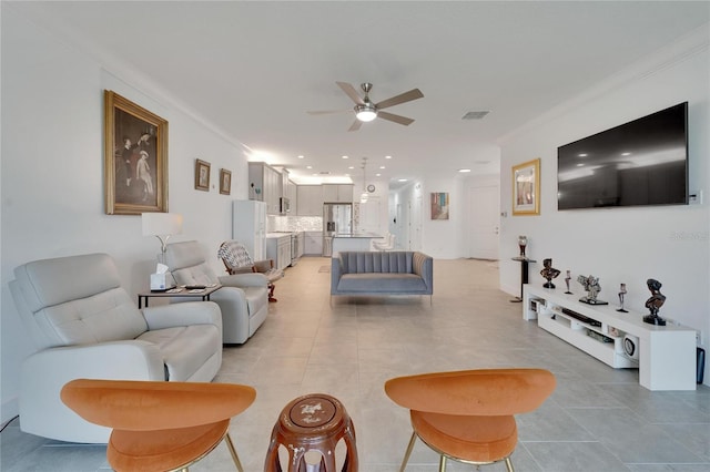 tiled living room with ceiling fan and crown molding