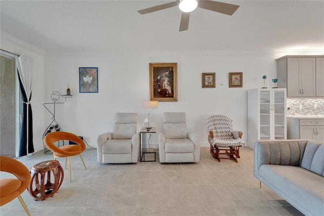 living room with ceiling fan and ornamental molding