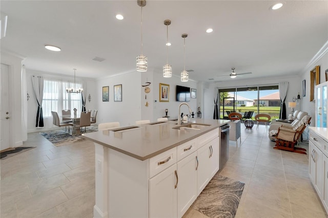 kitchen featuring white cabinetry, a kitchen island with sink, sink, and hanging light fixtures