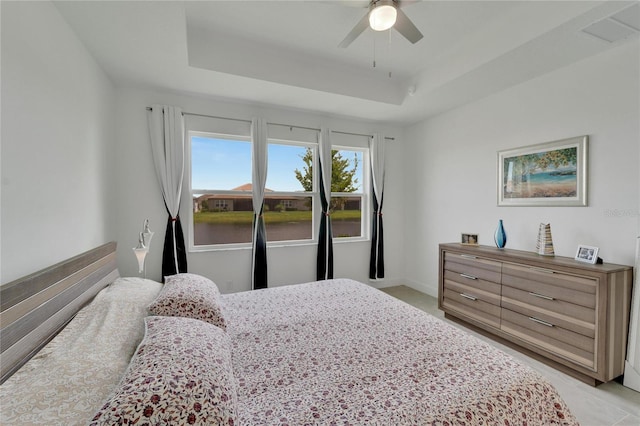 bedroom featuring a raised ceiling and ceiling fan