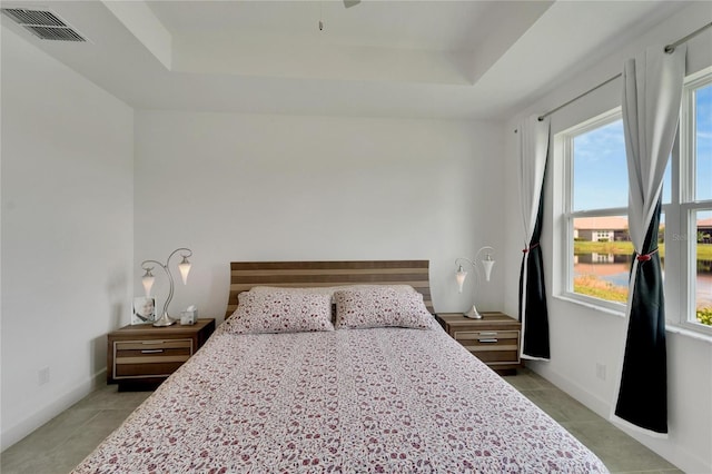 bedroom featuring a tray ceiling and light tile patterned flooring