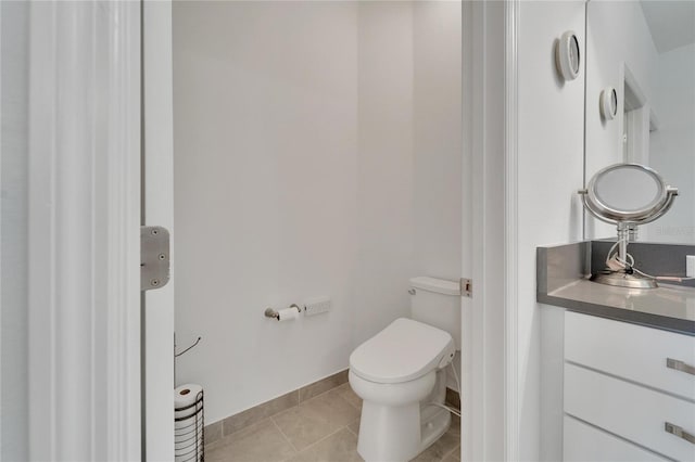 bathroom with tile patterned flooring, vanity, and toilet