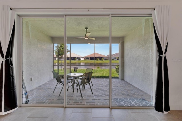 unfurnished sunroom featuring ceiling fan