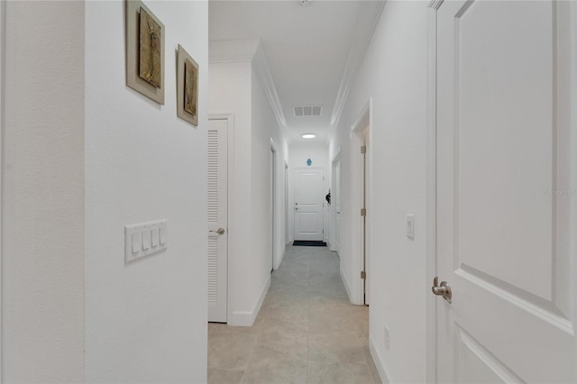 corridor with light tile patterned floors and crown molding