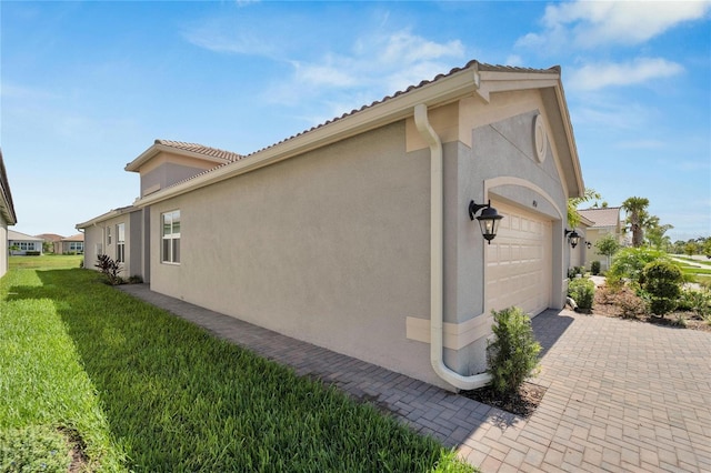 view of property exterior with a garage and a yard