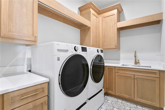 laundry area featuring sink, cabinets, and independent washer and dryer