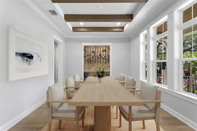 dining space featuring hardwood / wood-style floors, crown molding, and a raised ceiling