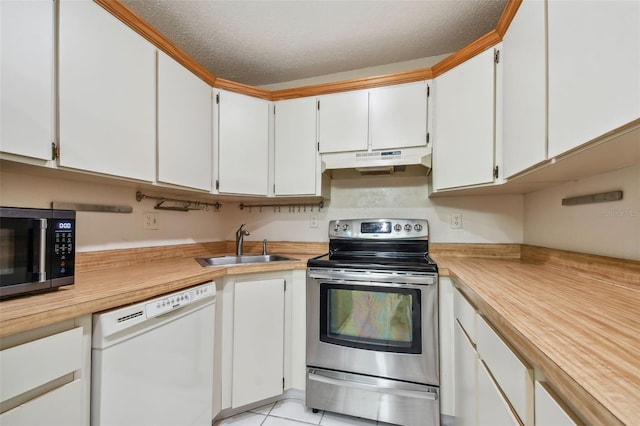 kitchen featuring a textured ceiling, stainless steel appliances, sink, light tile patterned floors, and white cabinets